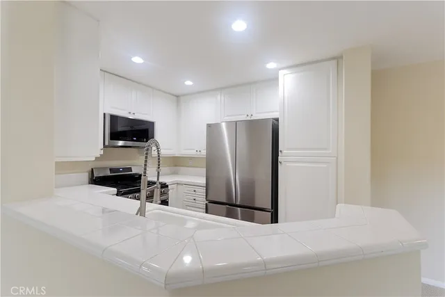 a room with a flat screen tv and a refrigerator