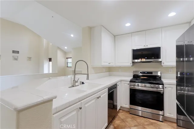 a kitchen with stainless steel appliances a stove sink and cabinets