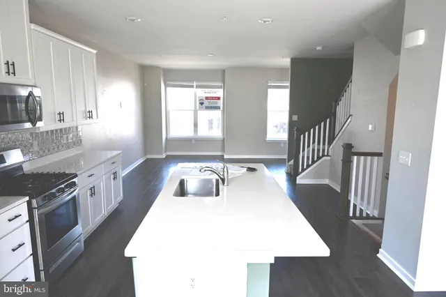 a kitchen with sink stove and cabinets