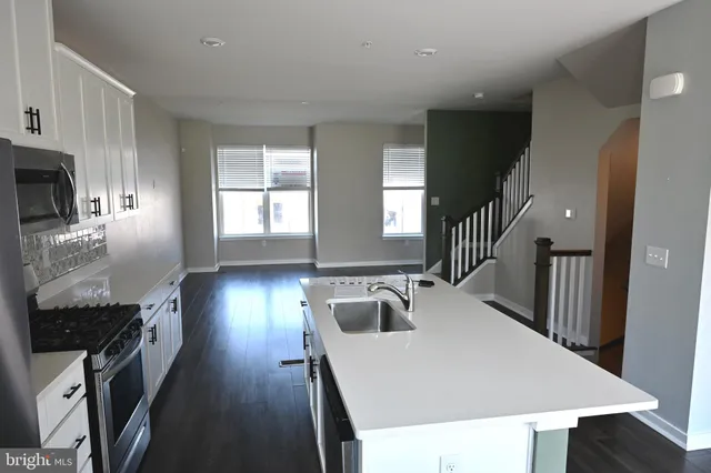 a kitchen with a sink a stove and cabinets