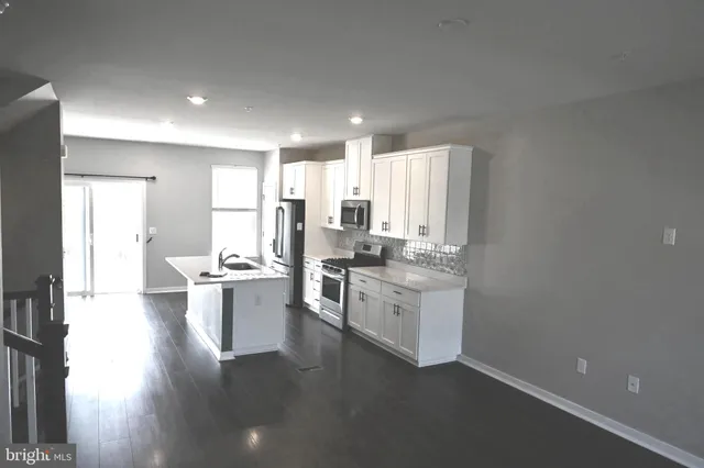 a view of a living room and kitchen with a floor to ceiling window