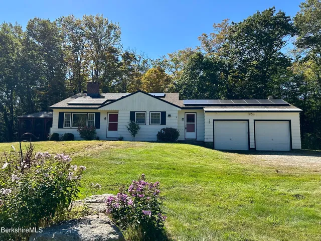 a front view of a house with yard and green space