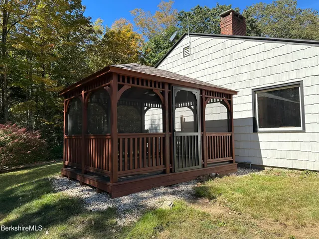 a view of a small house with wooden fence