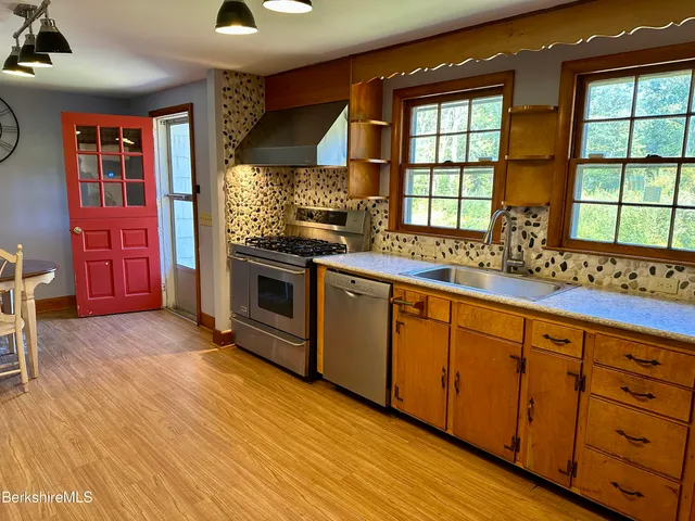 a kitchen with stainless steel appliances granite countertop a stove a sink and a refrigerator