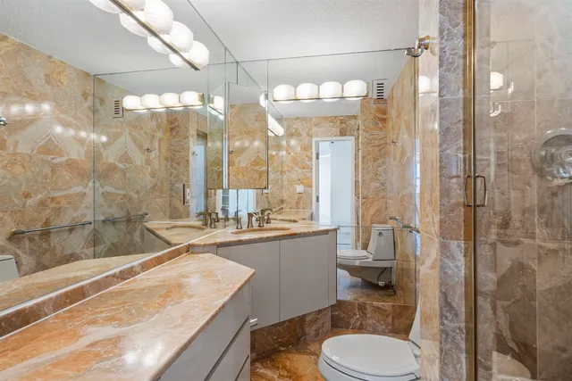 a bathroom with a sink a toilet and shower