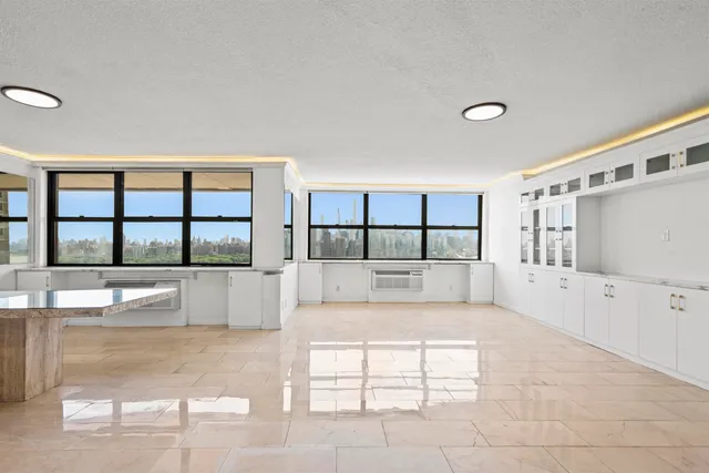 a large white bed in a large room with a large window