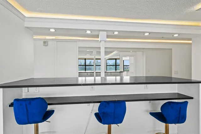 a kitchen with a table chairs and a potted plant