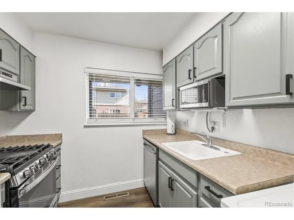 a kitchen with stainless steel appliances granite countertop a sink stove and microwave