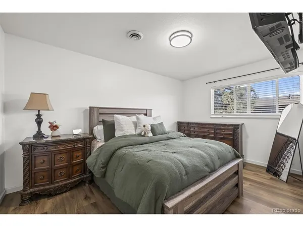a bedroom with a bed and a flat tv screen on dresser