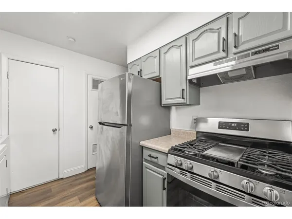 a kitchen with stainless steel appliances granite countertop a refrigerator a stove and a sink