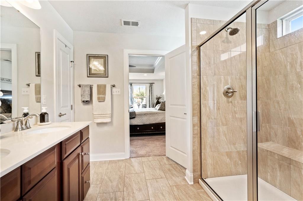 7660 Dominick Drive Irwin, PA 15642 - Photo 14 of 25 a en suite bathroom with a double vanity sink a mirror and a shower