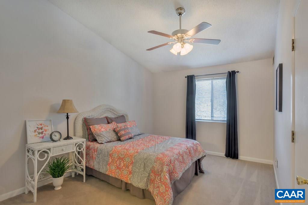 101 Turtle Creek Road, Unit 12 Charlottesville, VA 22901 - Photo 12 of 36 a bedroom with a bed and a chandelier