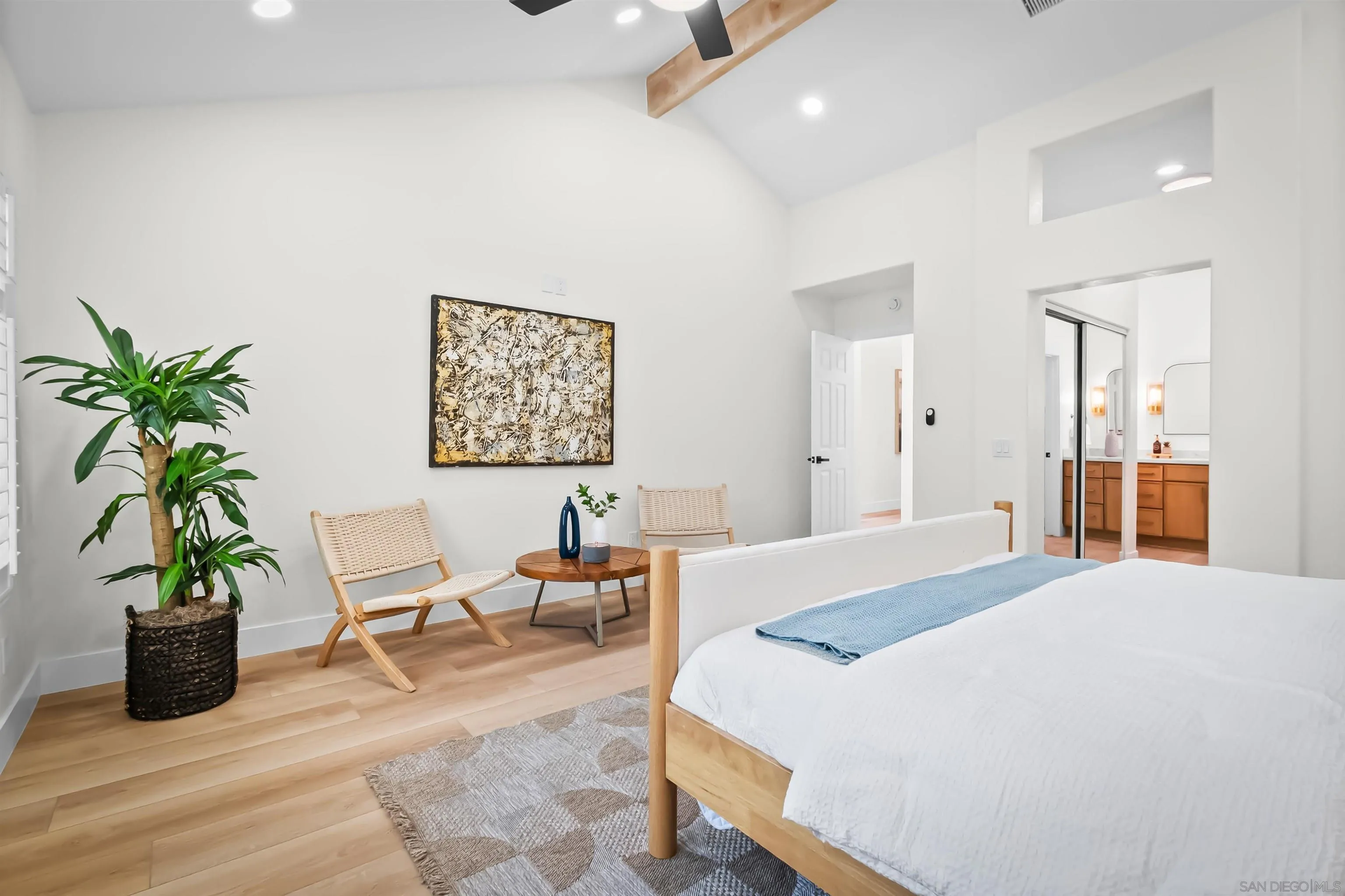 4058 Lemnos Way Oceanside, CA 92056 - Photo 18 of 47 a bedroom with a large bed a potted plant and a large window