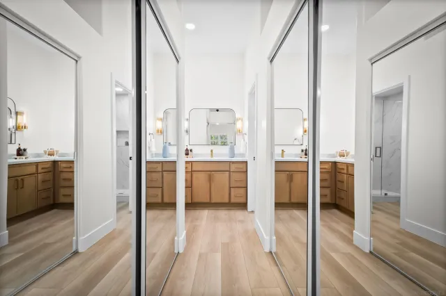 a large white kitchen with a sink and stainless steel appliances