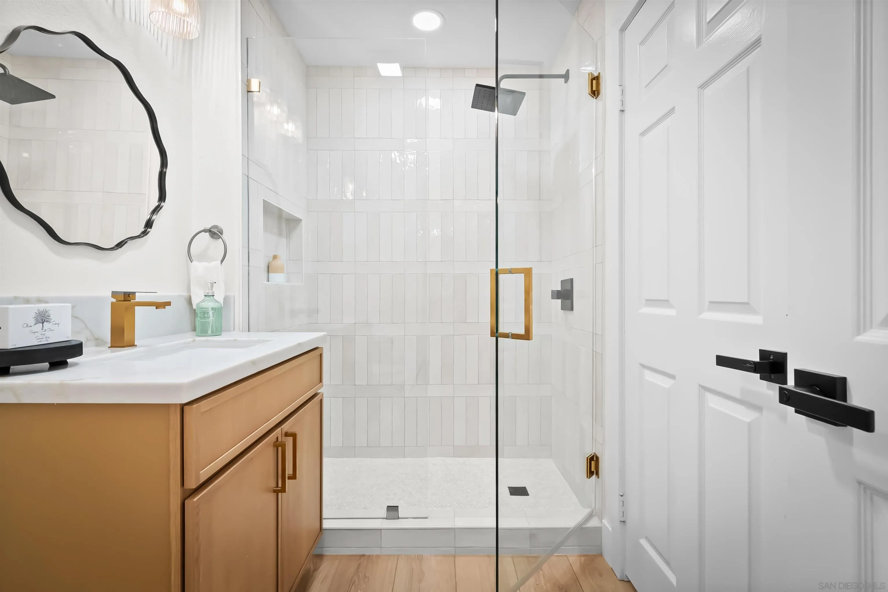 4058 Lemnos Way Oceanside, CA 92056 - Photo 30 of 47 a bathroom with a granite countertop sink a mirror and a shower