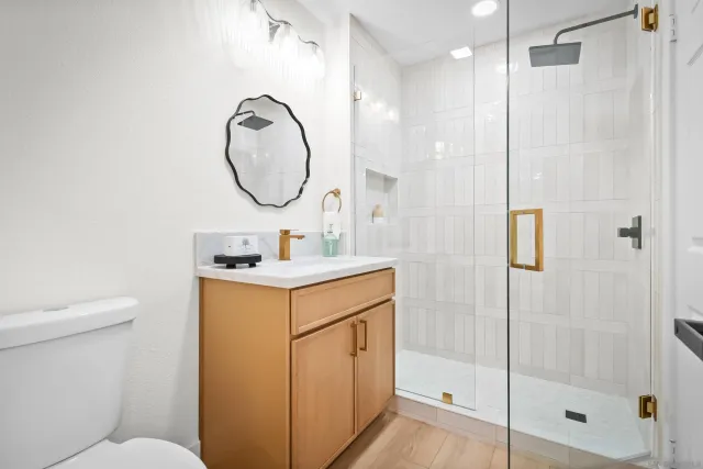 a bathroom with a toilet sink vanity and shower
