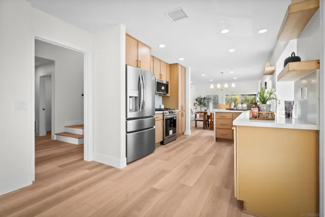 a kitchen with stainless steel appliances a refrigerator and a stove top oven