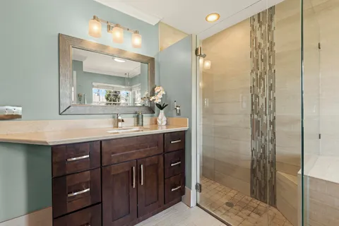 a bathroom with a double vanity sink mirror and shower