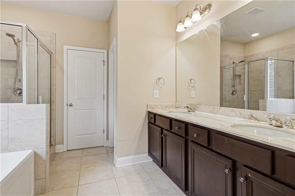 114 Madison Street Canton, GA 30115 - Photo 28 of 39 a bathroom with a double vanity sink a mirror and a bathtub