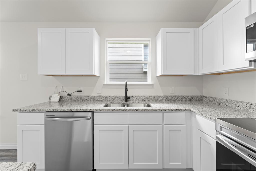 114 Goel Street Greenville, TX 75402 - Photo 18 of 32 a kitchen with white cabinets appliances and a sink