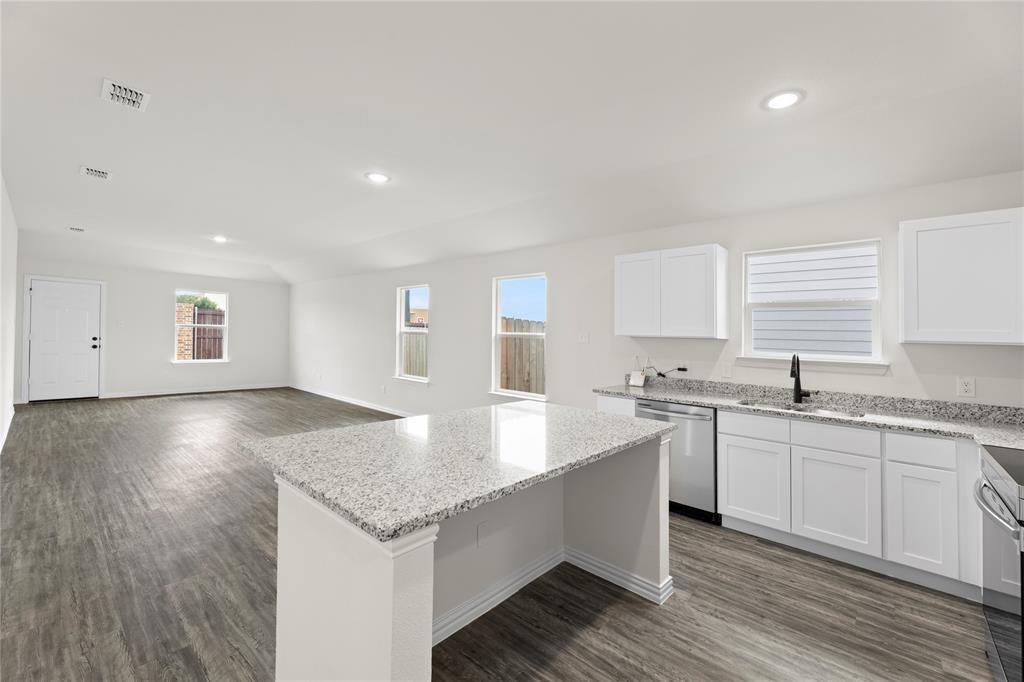 114 Goel Street Greenville, TX 75402 - Photo 20 of 32 a kitchen with granite countertop a sink and stove top oven
