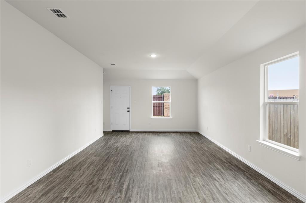 114 Goel Street Greenville, TX 75402 - Photo 24 of 32 an empty room with wooden floor and windows