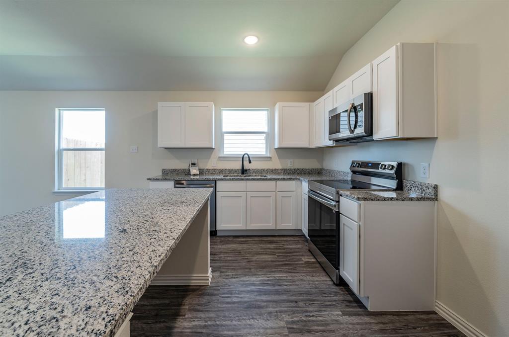 114 Goel Street Greenville, TX 75402 - Photo 5 of 32 a kitchen with stainless steel appliances granite countertop a stove a sink and a microwave