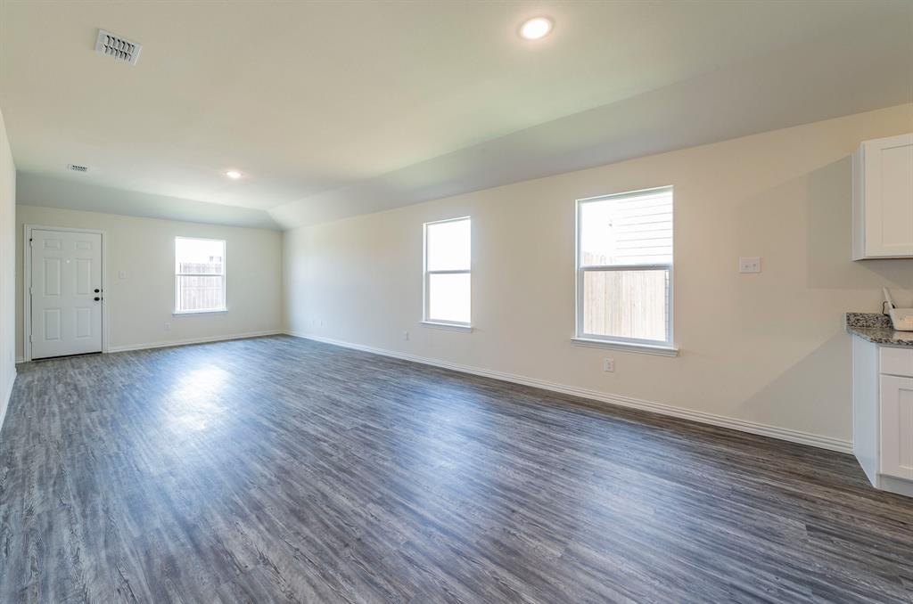 114 Goel Street Greenville, TX 75402 - Photo 9 of 32 an empty room with wooden floor and windows