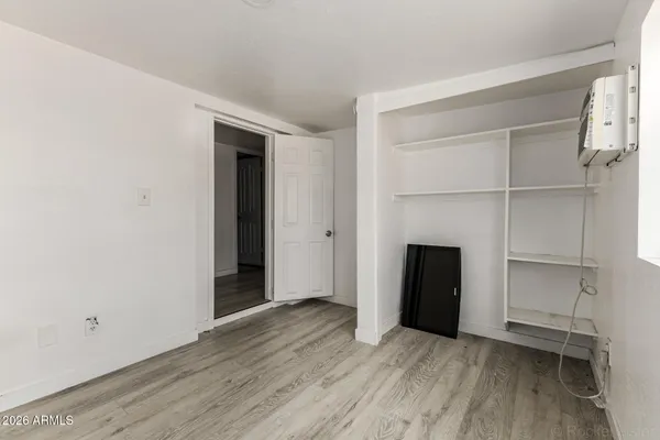 an empty room with wooden floor closet and fireplace