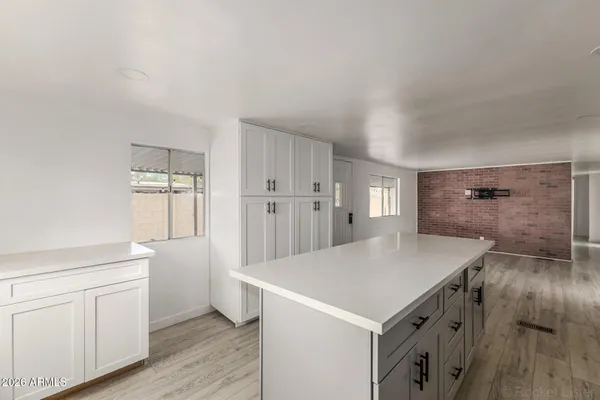 a kitchen with a stove a refrigerator and white cabinets