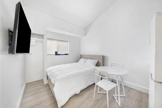 a bedroom with a bed and a flat screen tv