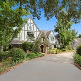 an front view of a house with a yard and fountain