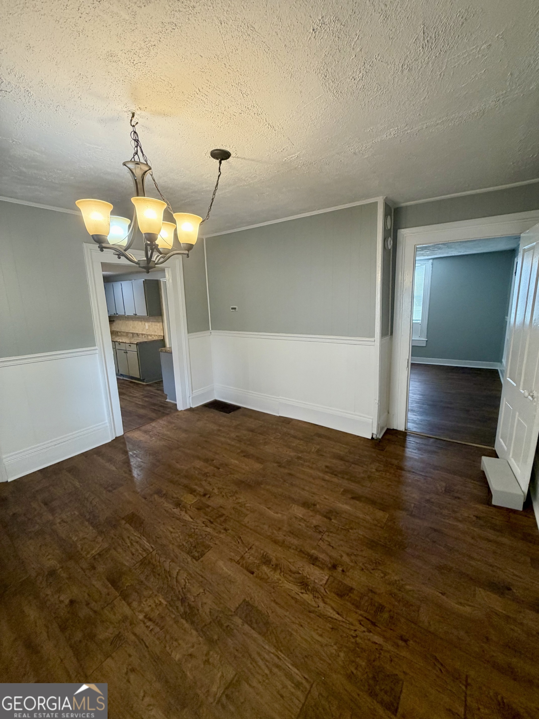 666 Woolfolk Street Macon, GA 31217 - Photo 16 of 60 a view of a room with wooden floor staircase and a kitchen