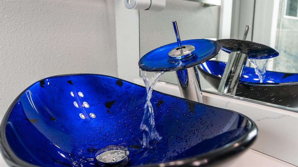 13032 Rudy's Way Streetman, TX 75859 - Photo 23 of 40 Close-up of blue glass vessel sink adding lake-inspired style to the bathroom.