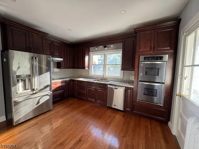 a kitchen with granite countertop stainless steel appliances and wooden cabinets