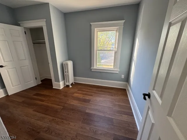 a view of a room with wooden floor and a window