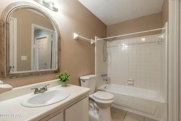 a view of an empty room and chandelier fan