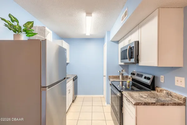 a kitchen with stainless steel appliances granite countertop a refrigerator sink and cabinets