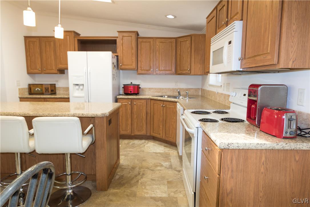 527 Norman Road Nazareth, PA 18064 - Photo 13 of 23 a kitchen with granite countertop a sink stove and white cabinets