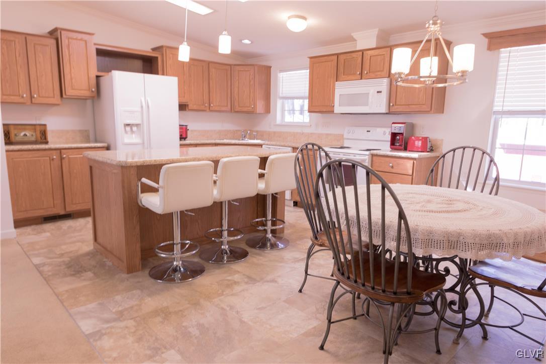 527 Norman Road Nazareth, PA 18064 - Photo 10 of 23 a kitchen with a dining table chairs and a refrigerator