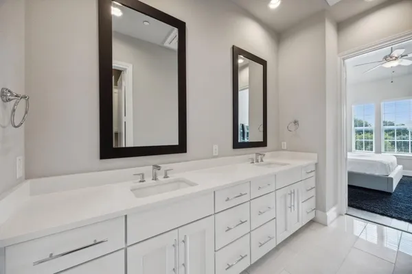 a bathroom with double vanity sinks and a mirror