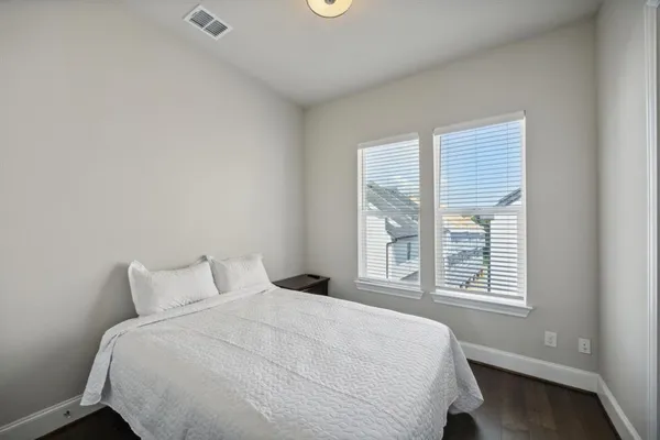 a large bed sitting in a bedroom next to a window