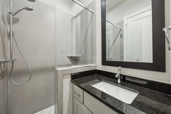 a bathroom with a granite countertop sink and a mirror