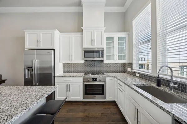 a kitchen with stainless steel appliances granite countertop a sink stove and refrigerator