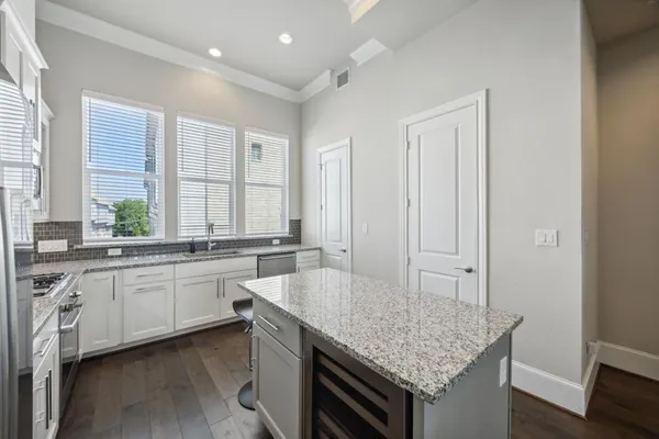 a kitchen with granite countertop a sink and white cabinets