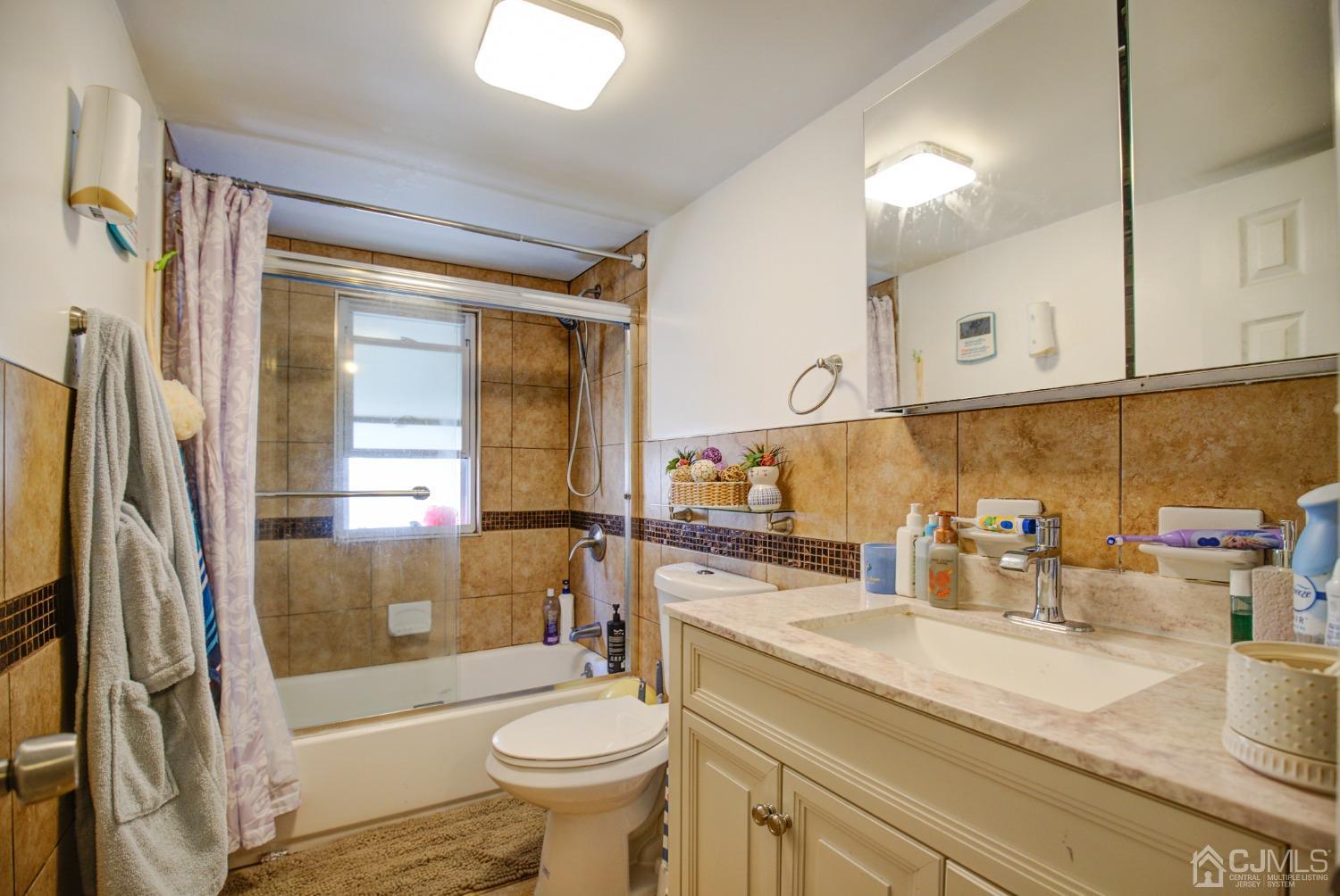 431 Baker Place Perth Amboy, NJ 08861 - Photo 14 of 16 a bathroom with a granite countertop sink toilet and shower