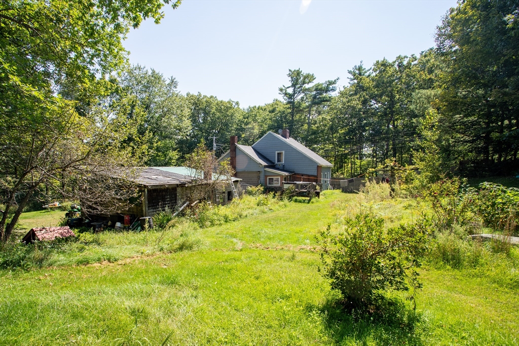 260 State Road Phillipston, MA 01331 - Photo 11 of 42 a backyard of a house with table and chairs under an umbrella
