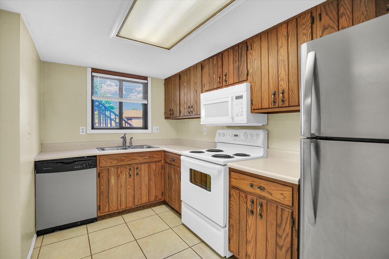 1905 Christopher Circle, Unit 4 Urbana, IL 61802 - Photo 13 of 29 a kitchen with stainless steel appliances granite countertop white cabinets a refrigerator a sink a stove a microwave and island