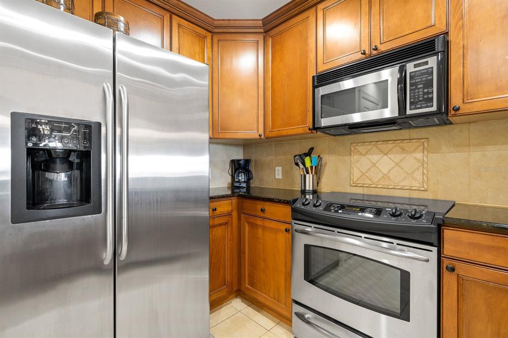 1370 Centre Ct Ridge Drive, Unit 401 Reunion, FL 34747 - Photo 11 of 51 a kitchen with stainless steel appliances granite countertop a stove a refrigerator and a microwave