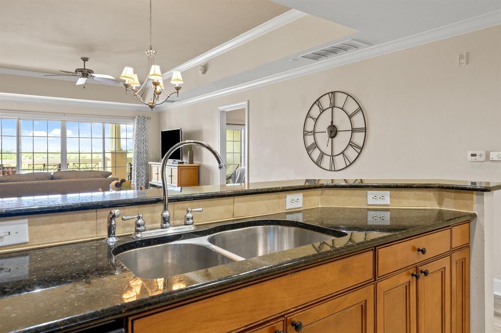 1370 Centre Ct Ridge Drive, Unit 401 Reunion, FL 34747 - Photo 12 of 51 a kitchen with a sink and a clock on the wall